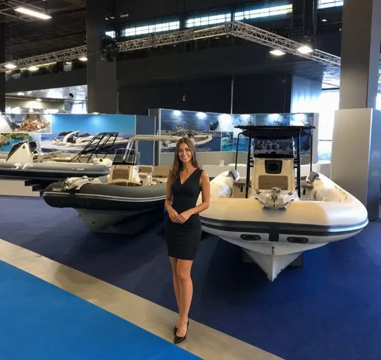 Exhibition stand at the Genoa Boat Show 2026 with Genoa Boat Show Hostess Agency 2026 personnel welcoming international buyers while exhibitors present yachts, sailing boats, marine engines, navigation technologies and innovative nautical solutions. The environment is modern and dynamic, with a continuous flow of industry professionals. Hostess staff manage first interactions, facilitate networking and enhance brand image with precision and elegance, reflecting the importance of the event and the strategic role of qualified personnel.